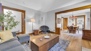 Un salon moderne comprenant un canapé, une table basse et un coin repas avec des chaises et une table.