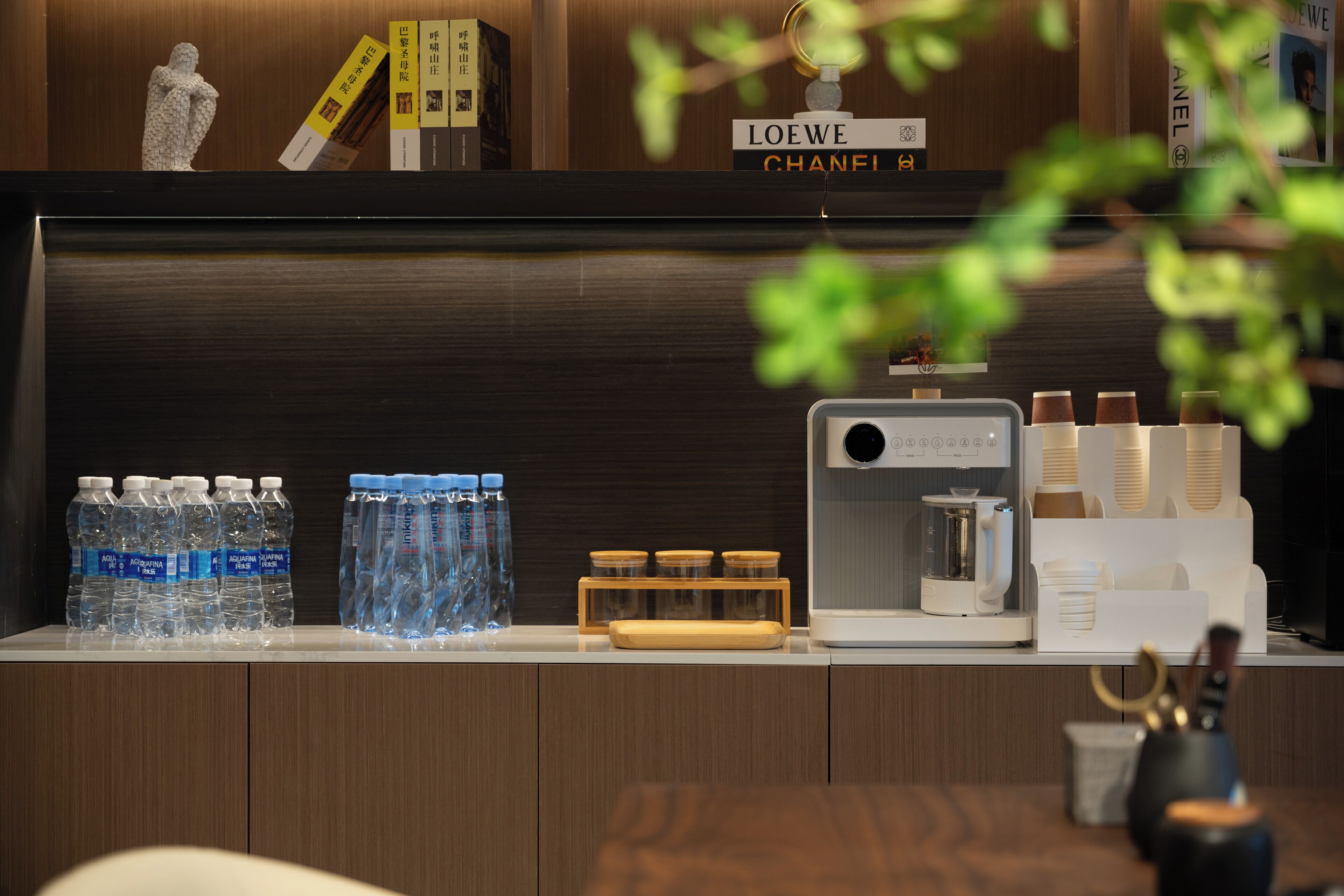 Ein Empfangsbereich mit Wasserspender, Kaffeeautomat und ordentlich sortierten Pflegeprodukten.