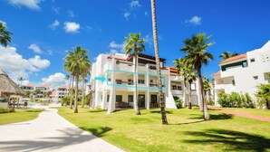 A resort with a central building, palm trees, and a pathway.
