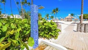 A blue-tiled structure, a wooden deck, and palm trees.