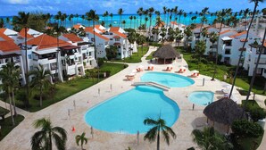 A resort with multiple swimming pools, palm trees, and ocean views.