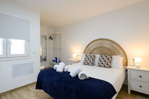 A bedroom with a bed, bedside tables, a wardrobe, a mirror, and a window.