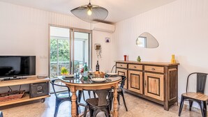 Ein Essbereich mit Holztisch, Stühlen, einem Fernseher und einem Schrank.