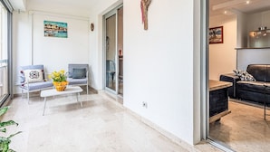 Ein modernes Wohnzimmer mit einer Couch, Sesseln, einem Couchtisch und einem Essbereich.