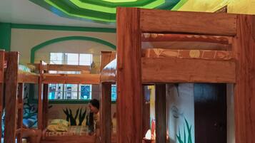 A room with bunk beds, a green and white color scheme, and a unique ceiling design.