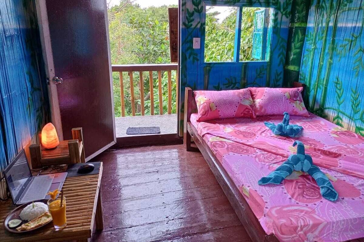 Una habitación con una cama, una computadora portátil, un calefactor y vistas a zonas verdes.