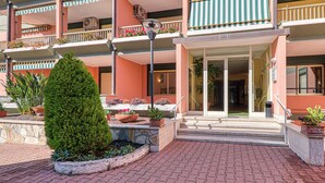 A multi-story building with balconies, a central entrance, and potted plants. - Imperiale Residence Bilocale with Terrace and A/C, Sanremo, Italy (Sanremo)