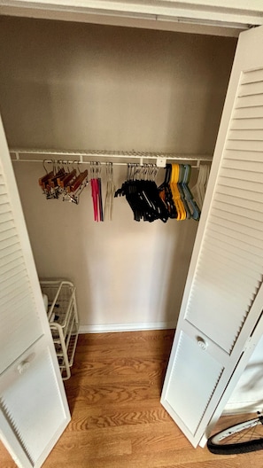 Un vestidor con piso de madera, paredes y techo blancos.