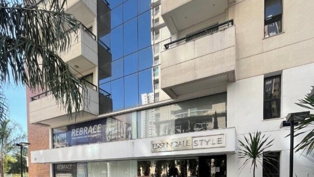 Ein modernes Gebäude mit einer Schaufensterfront, auf der 'REBRACE' und 'ESSENTIAL STYLE' stehen.