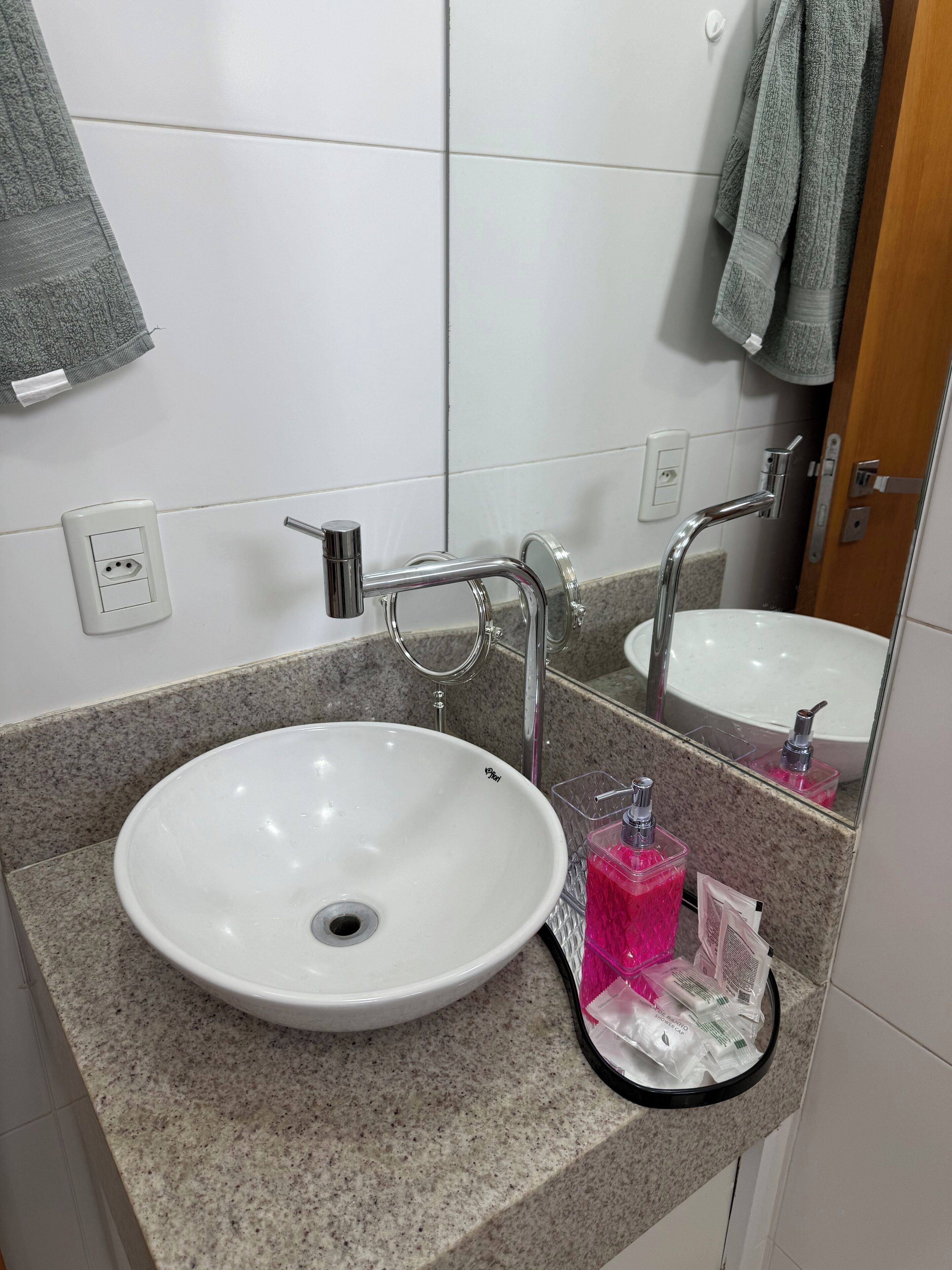 A bathroom with a white sink, a mirror, and a granite countertop.