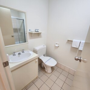 Een bad/douchecombinatie, handdoeken, zeep, shampoo