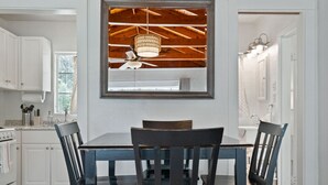 Un espace repas doté d’un plafond en bois, d’un ventilateur de plafond et d’un lustre.