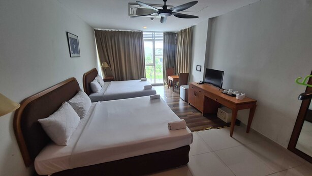 A hotel room with two beds, a desk with a TV, and a ceiling fan. - Hotel O De Melor Bangi Gateway (Bandar Baru Bangi)