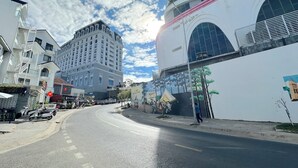 Ein mehrstöckiges Gebäude mit einer geschwungenen Fassade, großen Fenstern und einem markanten Eingangsbereich mit Vordach.