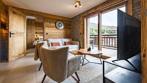Une pièce chaleureuse avec un décor intérieur en bois, un canapé, une table basse et un téléviseur.