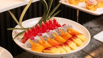 Una bandeja de frutas con pitahaya, mango y sandía sobre un plato blanco.