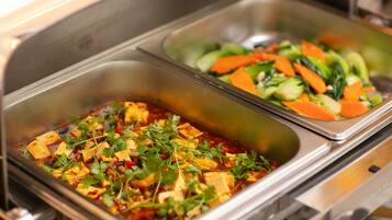 A buffet with two dishes: one with tofu and vegetables, and another with mixed vegetables.