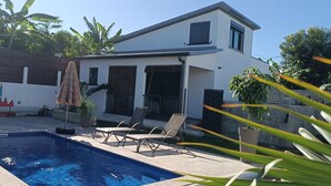 A modern house with a swimming pool, outdoor seating, and lush greenery. - Cosy, comfortable villa 15 minutes from the sea (Saint-Pierre)