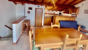 Una cocina acogedora con armarios de madera, una mesa de comedor y una silla azul.