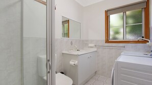 A bathroom with a shower, toilet, sink, and a window with a view. - Canyon Walk Unit - Located in the heart of Bright (Bright)