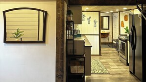Een ruime keuken met een houten plafond, een eethoek en uitzicht op de woonkamer.