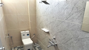 Un baño con inodoro, ducha, lavamanos y un dispensador de agua morado.