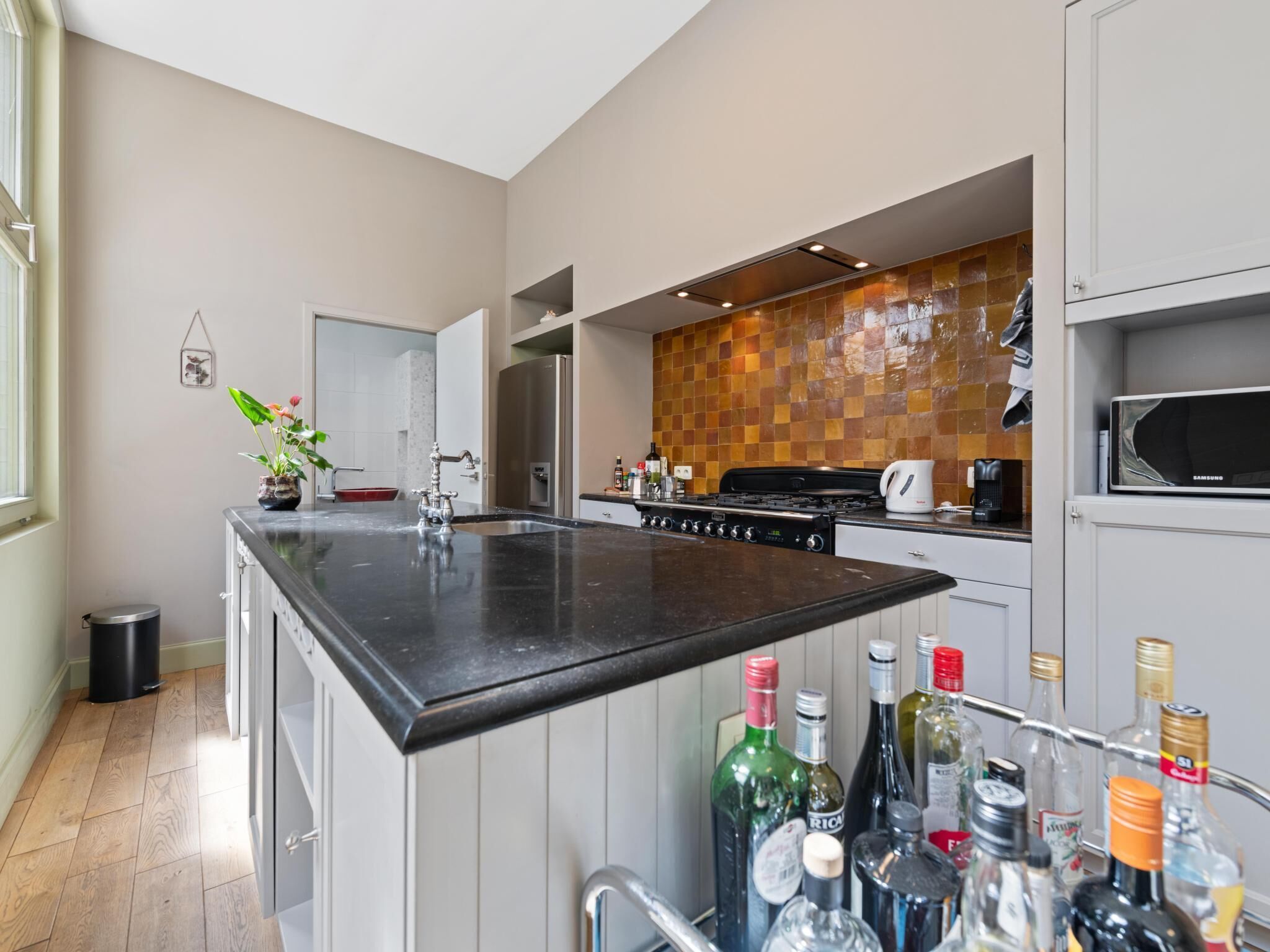 Una cocina moderna con una isla central, electrodomésticos de acero inoxidable y un salpicadero de azulejos.