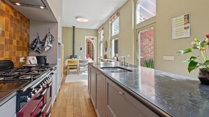 Une cuisine moderne équipée d’une cuisinière, d’un four et d’un grand îlot central avec un évier.