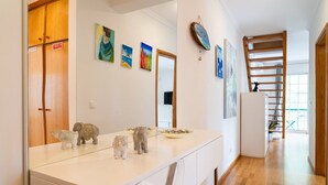 Une cuisine moderne avec un plan de travail blanc, un miroir et un plancher en bois.