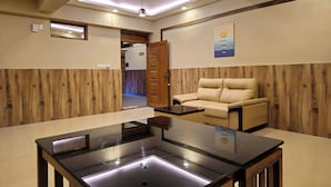 A modern living room with a sofa, a coffee table, and a ceiling with recessed lighting. - Alicos Residency (Sulthan Bathery)
