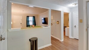 A hallway with a wooden ceiling, a trash can, and a television mounted on the wall. - < 1 Mi to Vanderbilt: Nashville Apt (Nashville)