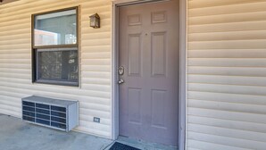 A house with a grey door, a window, and an air conditioning unit. - < 1 Mi to Vanderbilt: Nashville Apt (Nashville)