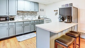Una cocina moderna con armarios grises, una isla grande y una estación para café.