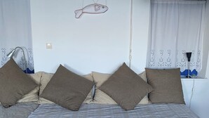 A cozy room with a sofa set, a chessboard on a table, and a wall-mounted fish decoration.