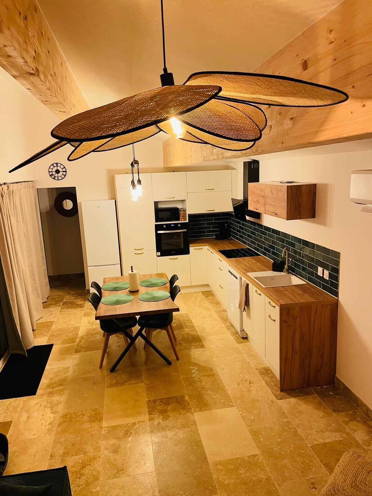 A modern kitchen with white cabinets, a wooden countertop, and a black microwave.
