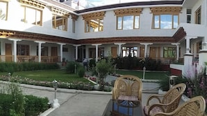 Un patio con zona de comedor, mobiliario exterior y un jardín cuidado.