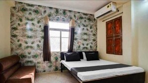 Une chambre à coucher avec un lit, une chaise, une fenêtre avec des rideaux et une armoire.