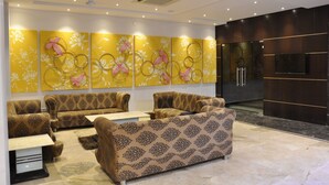 A modern living room with patterned sofas, a flat-screen TV, and decorative wall art.