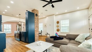 A spacious living area with a sofa, a coffee table, and a kitchen in the background.