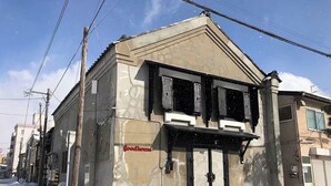 A building with a beige facade, a black-framed entrance, and the 'Goodhome' sign. - GoodHome Toyokawa (Hakodate)
