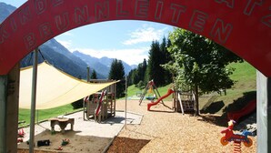 A playground with a red archway labeled "Kinderplatte Brunnenleiten" and various play equipment. - Apartment in Kleinarl near Ski Lift (Kleinarl)