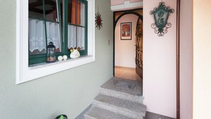 Una escalera conduce a una habitación con ventana, un adorno en la pared y una puerta con arco.