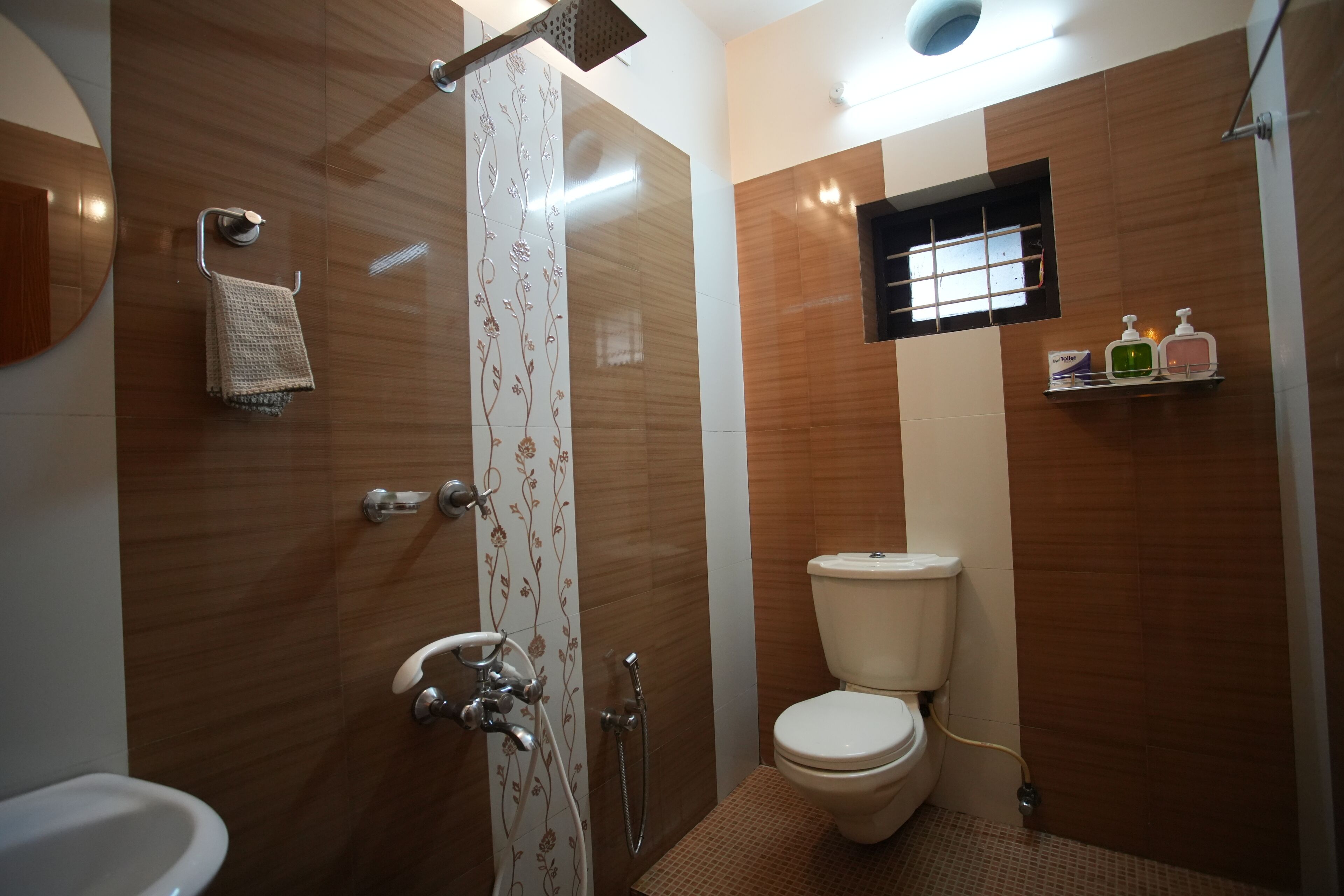 A modern bathroom with a shower, toilet, and sink.