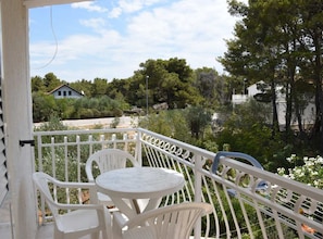 A balcony with white railings, a round table, and white plastic chairs. - Apartments Dana (Vodice)