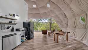 A spacious tent with a kitchen area, dining table, and chairs. - Nottely River Retreat | Fire Pit (Murphy)