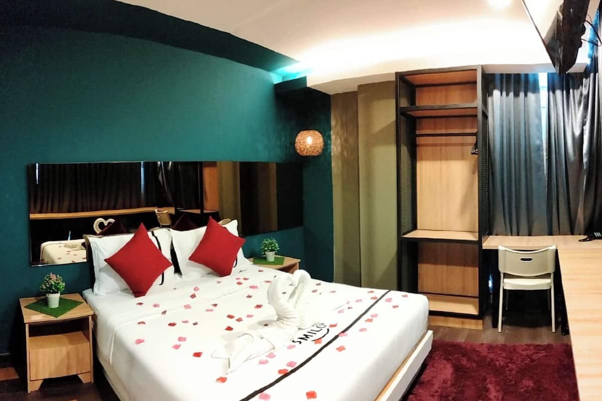 Une chambre d’hôtel bien rangée, avec un lit, un bureau et une chaise.