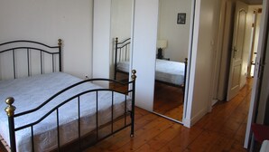 Ein Schlafzimmer mit Bett, Kleiderschrank und Spiegel.