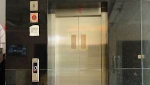 Un ascenseur doté d’un écran numérique, de boutons d’appel d’urgence et d’un panneau de commande.