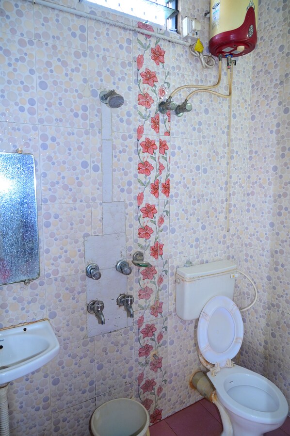 A bathroom with a toilet, sink, and shower.