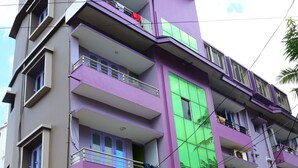 A multi-story building with balconies, a sign for 'Hotel Beach Heaven', and a parked scooter. - DhamStay Hotel Beach Heaven Puri (Puri)